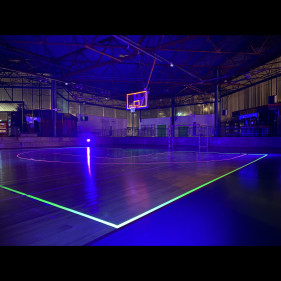 Gymnase en lumière noire, lignes du terrain fluo